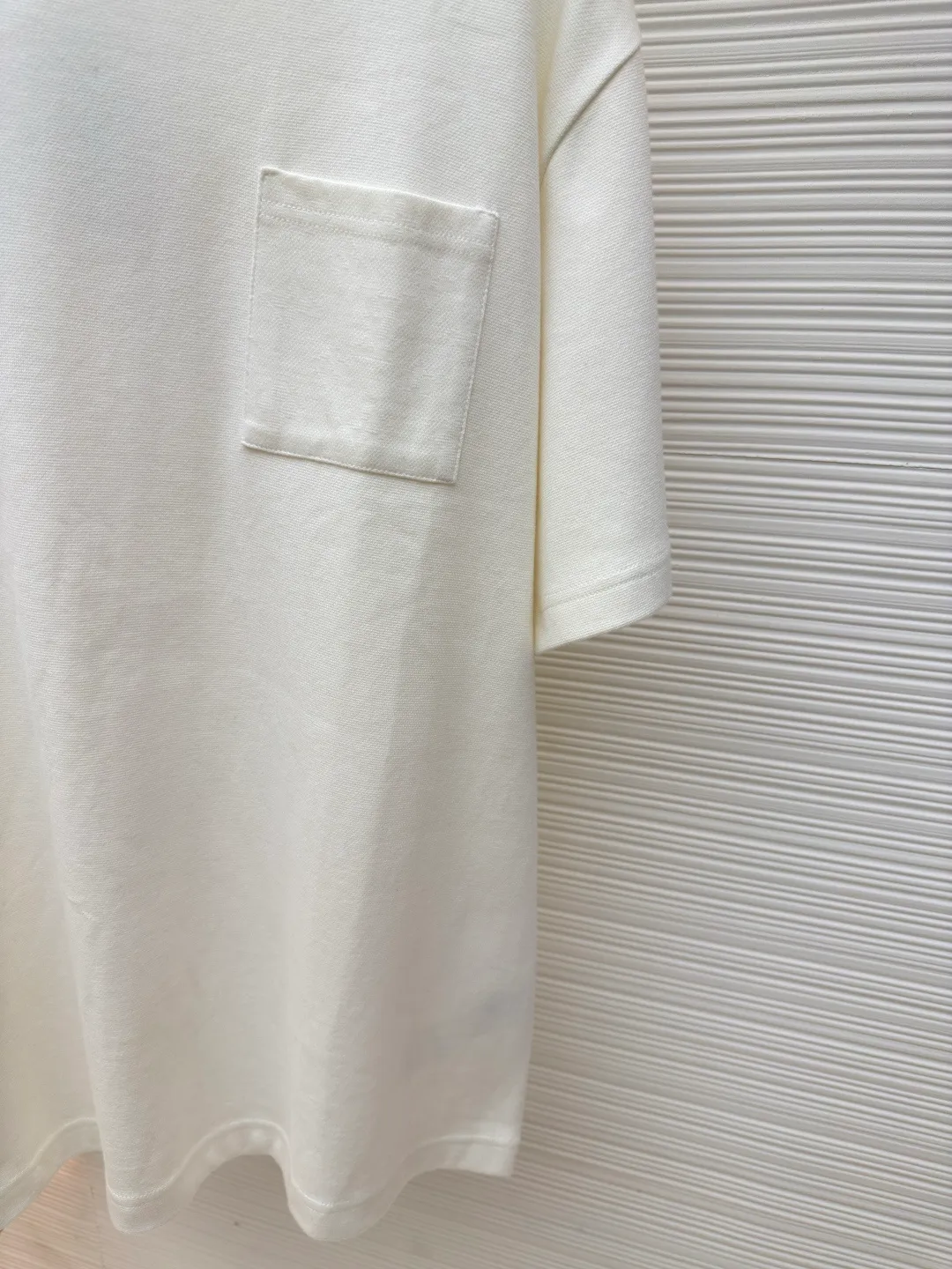 LOUIS VUITTON Pocket jacquard short sleeves ●Authentic product: purchased and developed for 8500 ●Item number: 1680117-A35 ●Fabric: pure cotton fabric ●Technology: jacquard knitting ●Version: fitted version ●Weight: about 345 grams ●Size: XS-S-M-L ●Description: Use 18-needle upper and lower cotton jacquard knitted fabric, weight 300g. Disassemble the original version to analyze the type of machine for yarn parameters. Manually count the needles and draw the pattern. The jacquard fabric is woven by Fukuda machine imported from Japan. The solid color part uses an 18-needle double-sided jacquard machine to weave the pique fabric. The jacquard and solid color fabrics are proportioned according to the amount of each piece. The two fabrics are the same The vat dyeing ensures that there is no color difference in the finished fabric. Overflow vat rope dyeing is used. The edge of the finished fabric is over-positioned and the weft adjuster is used to adjust the weft and slant to ensure that the pattern of the finished fabric is consistent with the size of the Y version. The front + sleeves are made of solid pique fabric, and the back pocket is made of jacquard fabric. The pocket letters are centered and positioned to take out the pieces. The thread is made of 40s double-ply cotton yarn and the flat collar is woven on a horizontal machine. The overall wiring is straight and delicate, the fabric is comfortable and soft, and the color is consistent without color difference. It can be matched with the same style to create a fashionable look and control various occasions. Customized accessories, complete with three standards, same style for men and women!